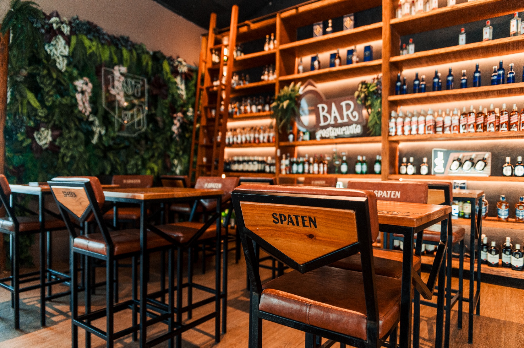 Bar Spaten com ambientação premium, estante iluminada e mobiliário exclusivo