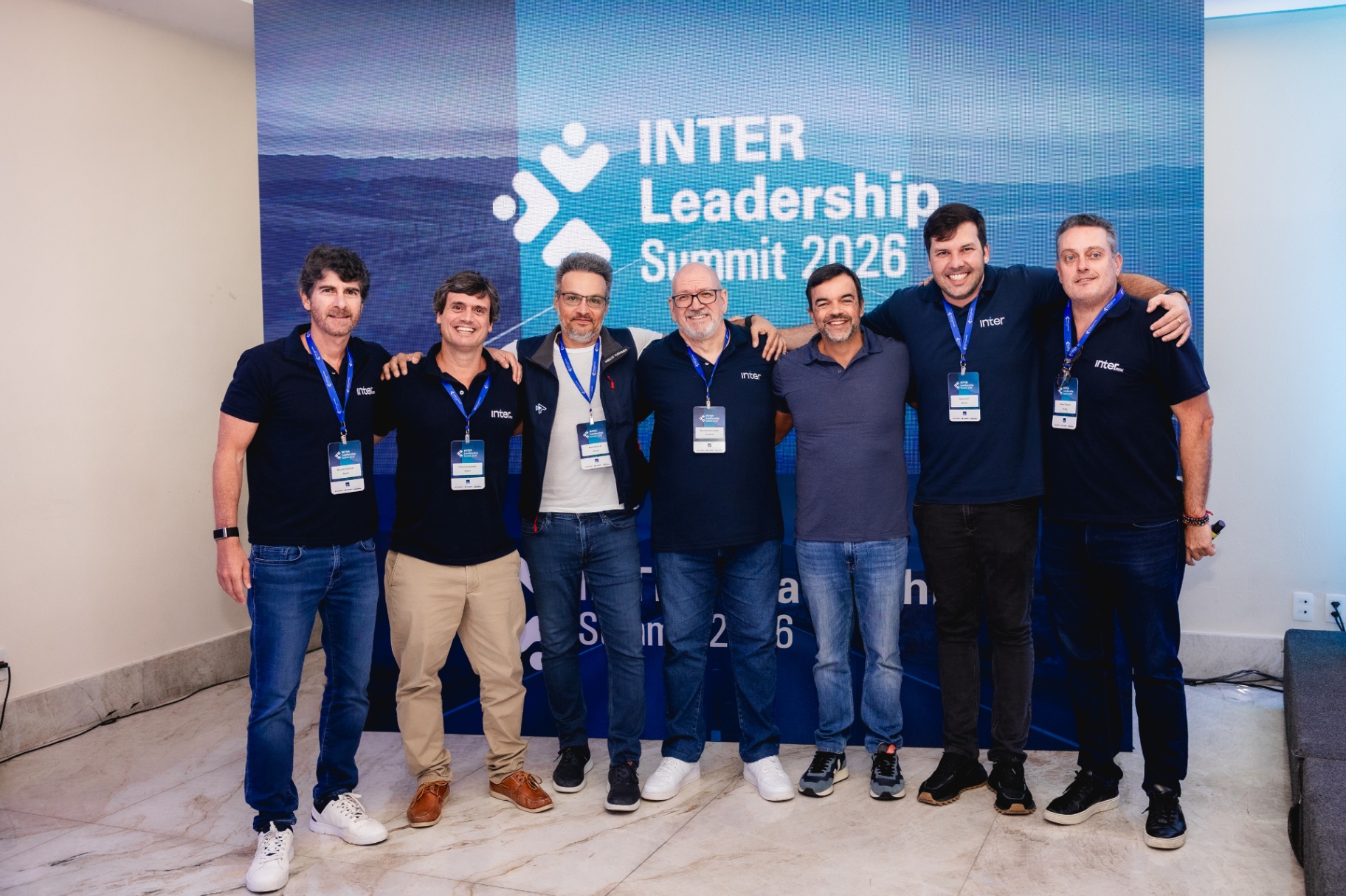 Equipe InterRisk reunida diante do painel de LED do Summit 2026