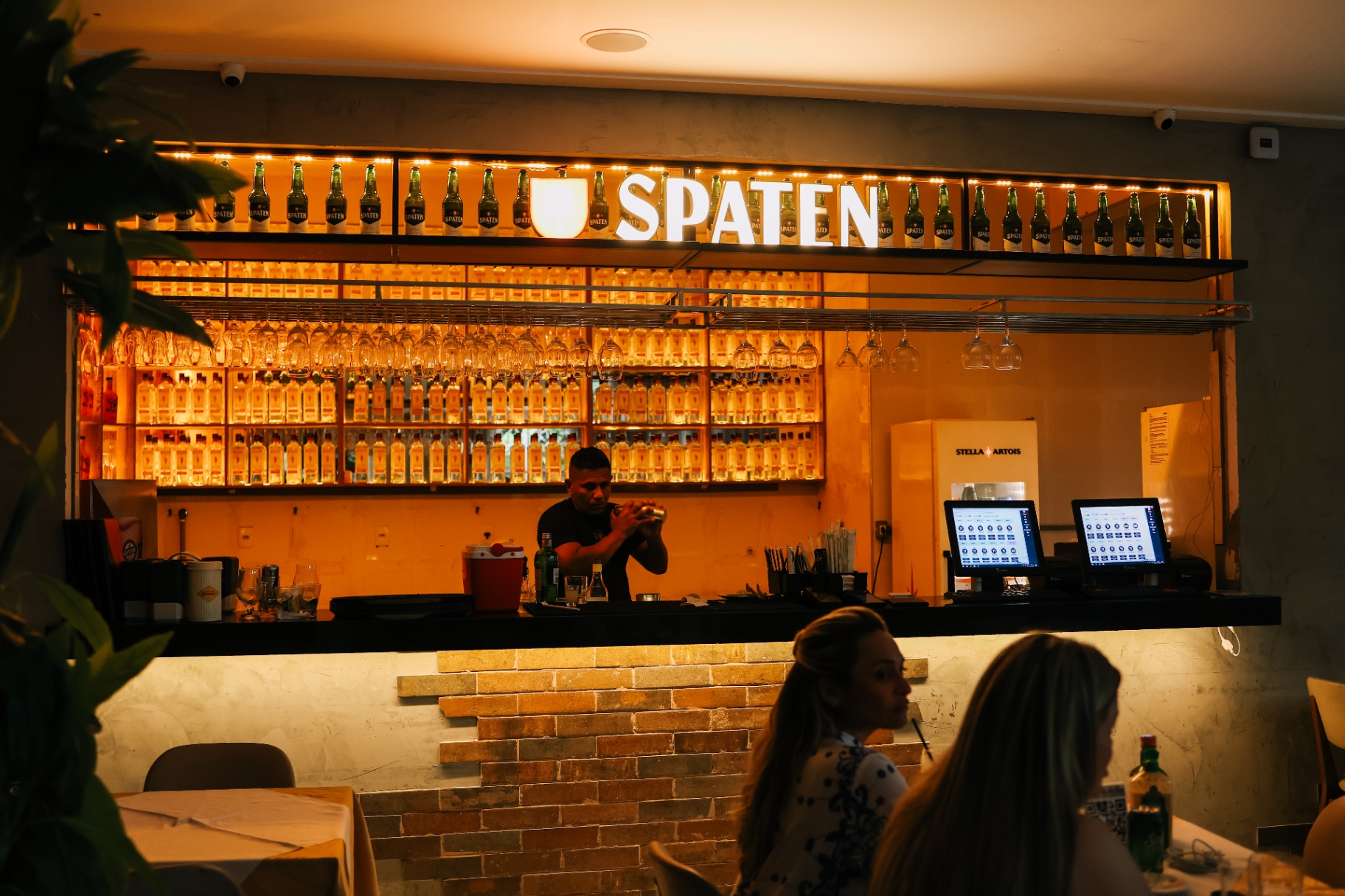 Balcão Spaten com backbar iluminado e operação em funcionamento
