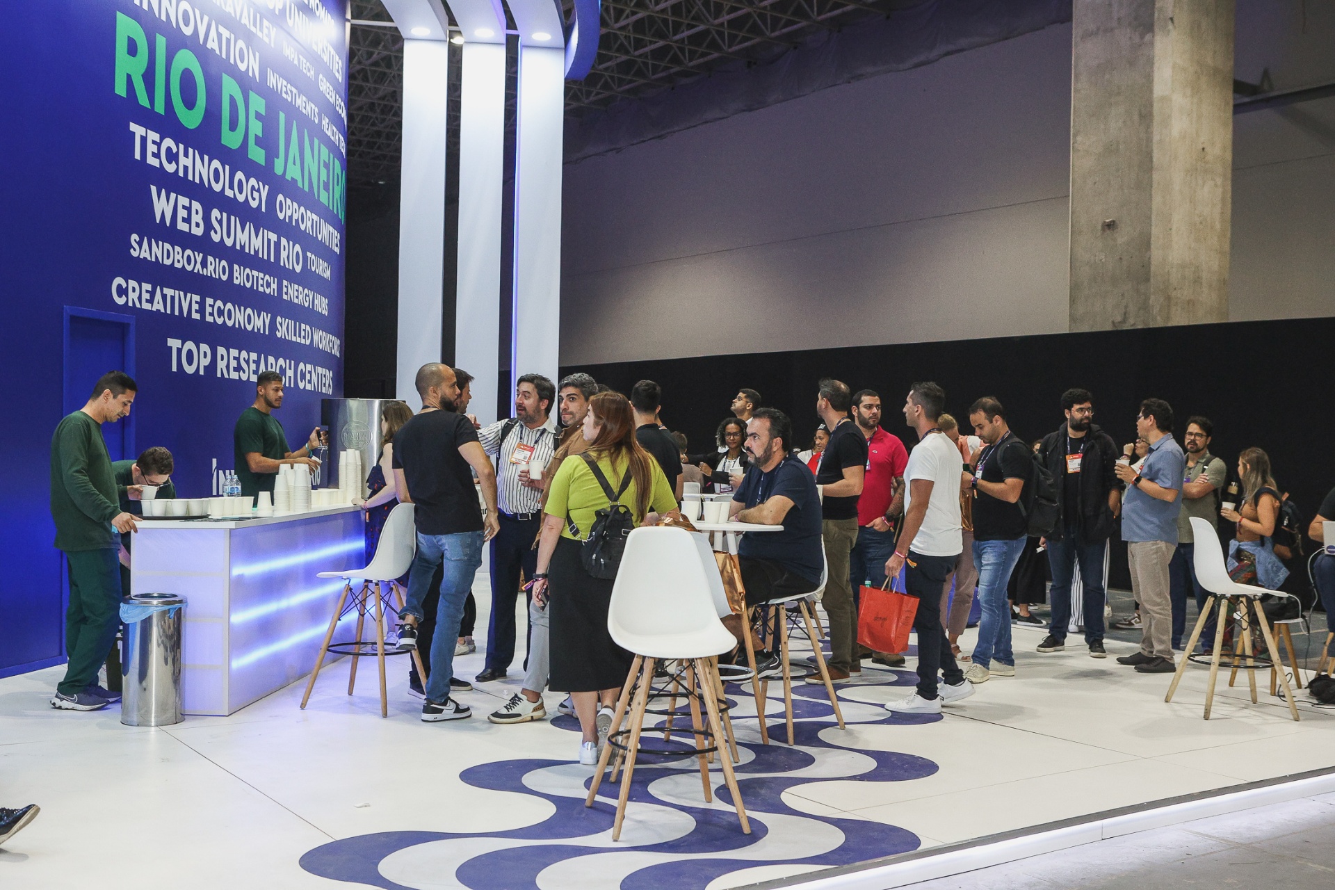 Área de coworking e business lounge com painel Rio de Janeiro e piso ondulado azul
